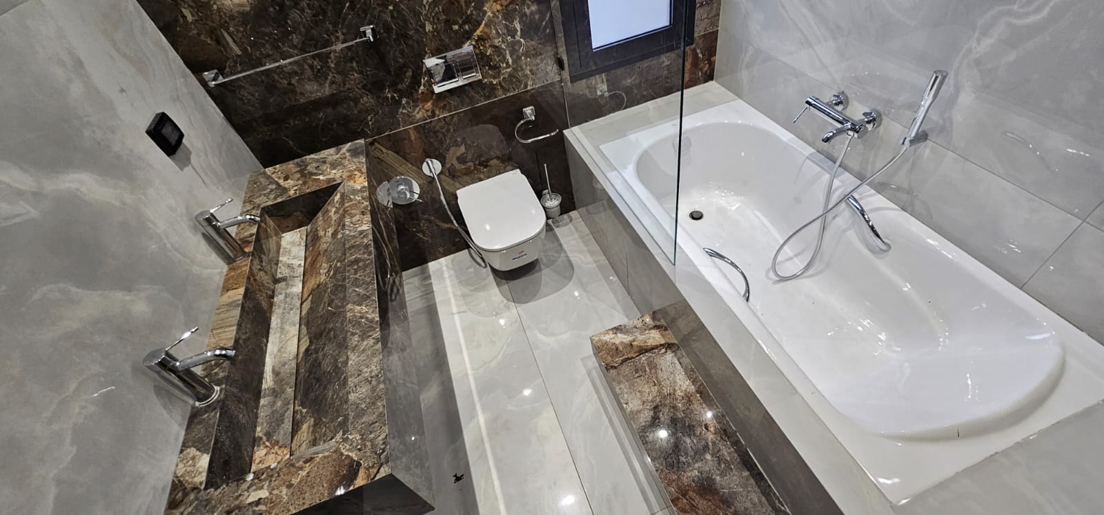 Salle de bains complète avec baignoire, vasque et revêtements minéraux